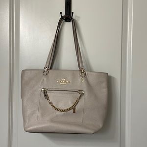 Coach purse. Tan color with three pockets on the inside.
